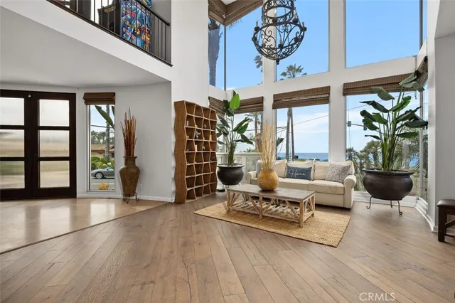 a living room with furniture kitchen view and a chandelier