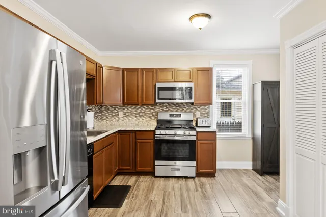 a kitchen with stainless steel appliances granite countertop a refrigerator and a stove top oven