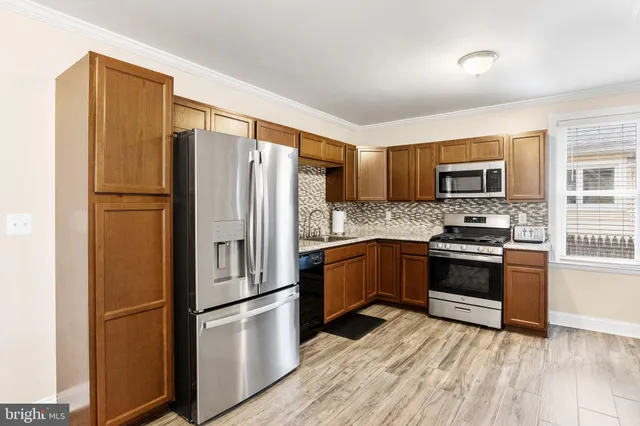 a kitchen with stainless steel appliances granite countertop a refrigerator stove and a sink