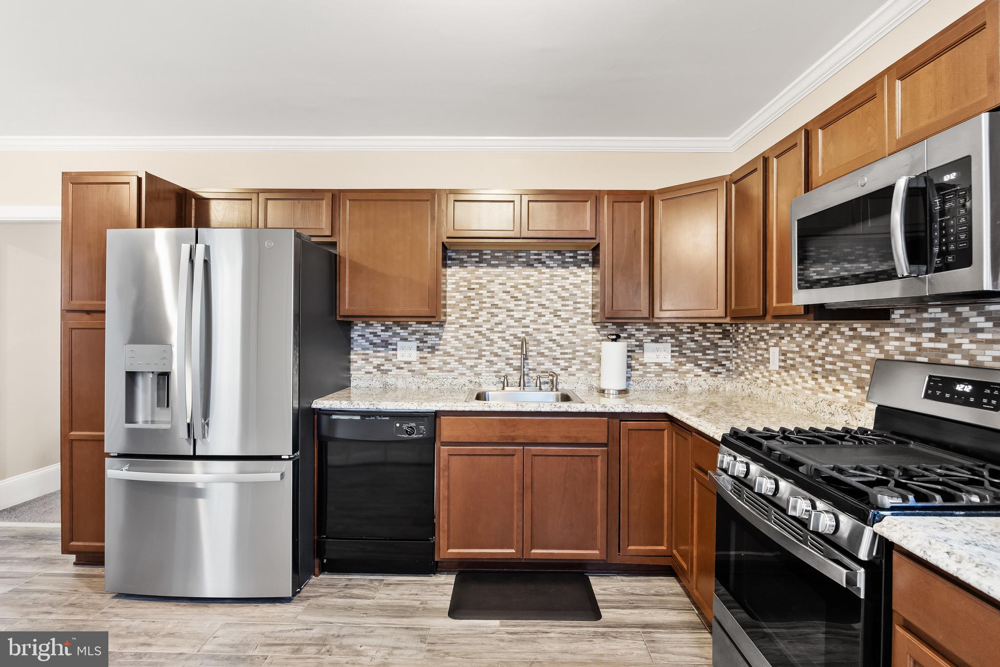 511 Ash Street Delanco, NJ 08075 - Photo 13 of 30 a kitchen with stainless steel appliances and wooden cabinets