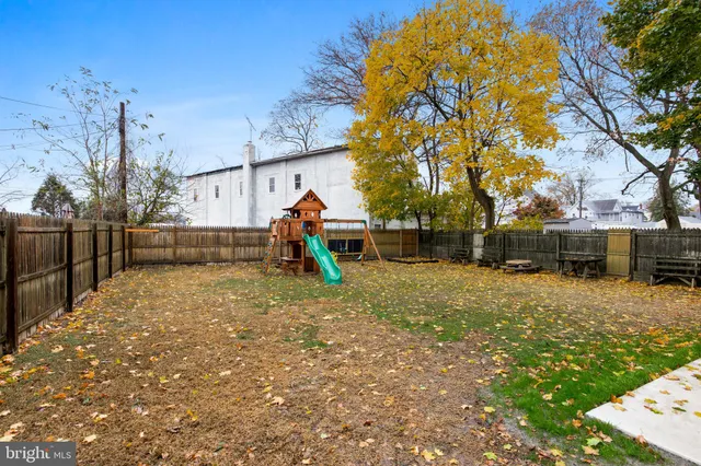 a view of backyard with wooden fence