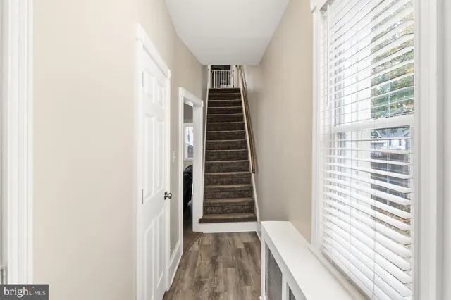 a view of a hallway with stairs and a window