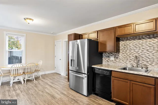 a kitchen with stainless steel appliances granite countertop a refrigerator and wooden cabinets