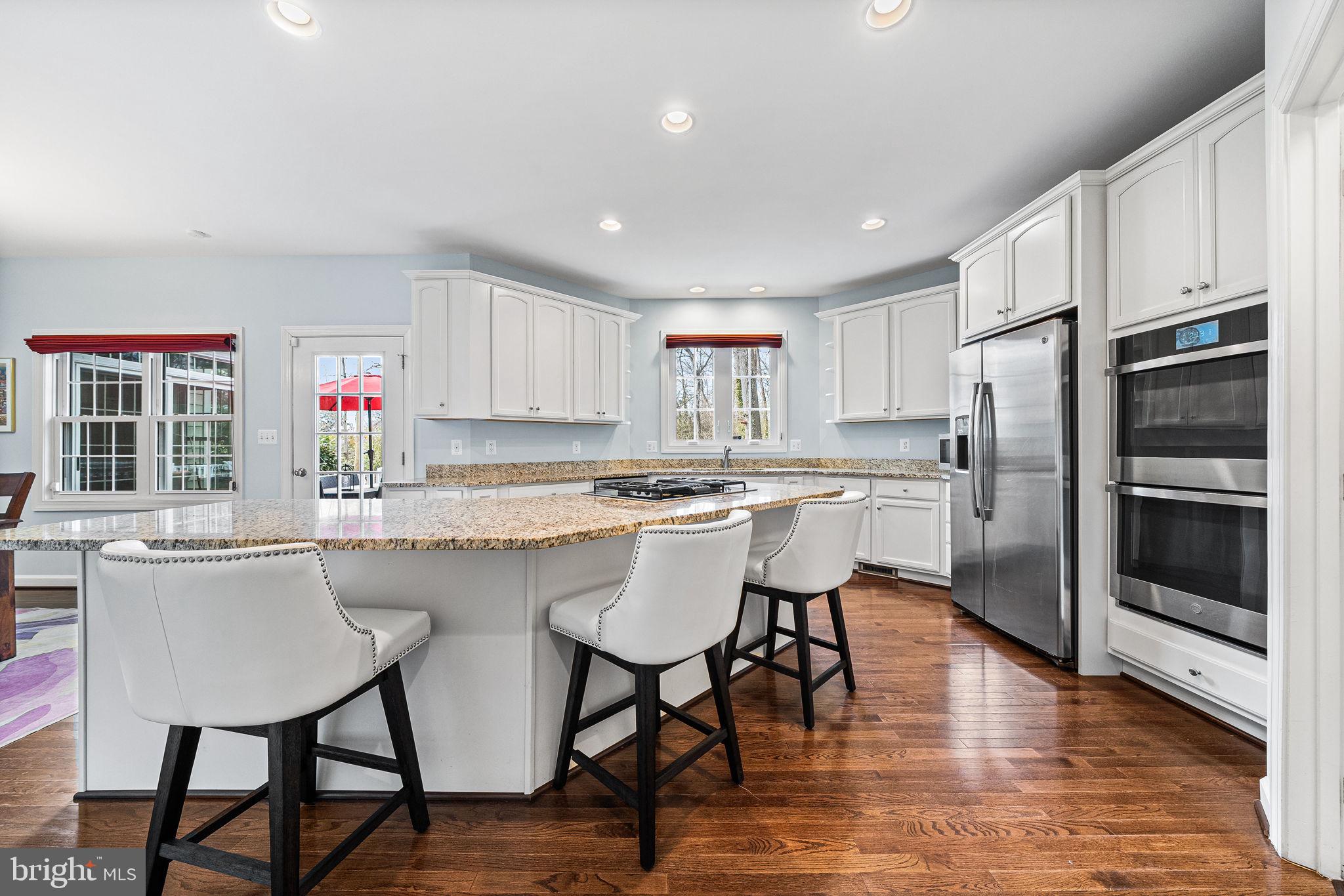 1232 Shenandoah Road Alexandria, VA 22308 - Photo 26 of 50 a kitchen with stainless steel appliances granite countertop a stove a sink a microwave a dining table and chairs
