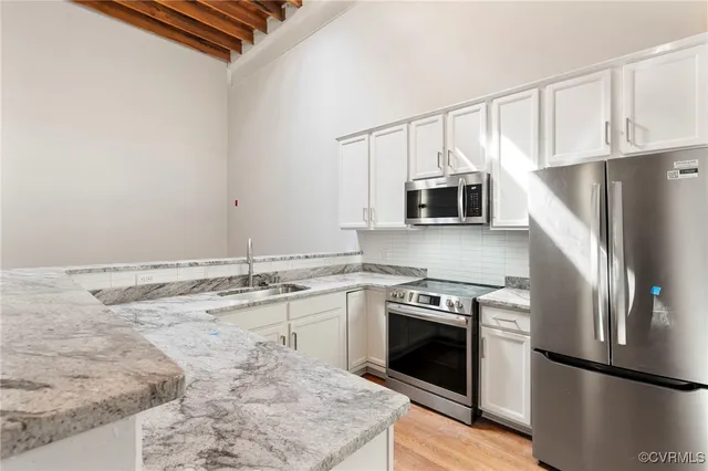 a kitchen with granite countertop a stove sink and refrigerator