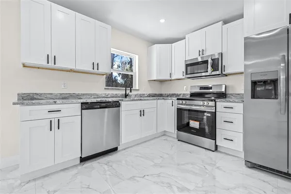 a kitchen with white cabinets stainless steel appliances and sink