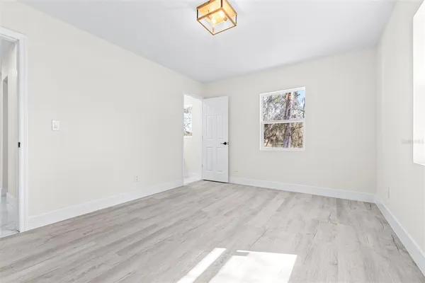 an empty room with wooden floor and window