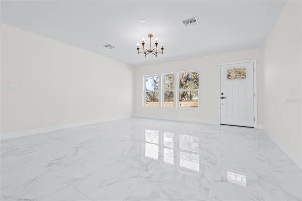 an empty room with windows and cabinet