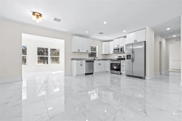 a kitchen with stainless steel appliances granite countertop a refrigerator and a stove top oven