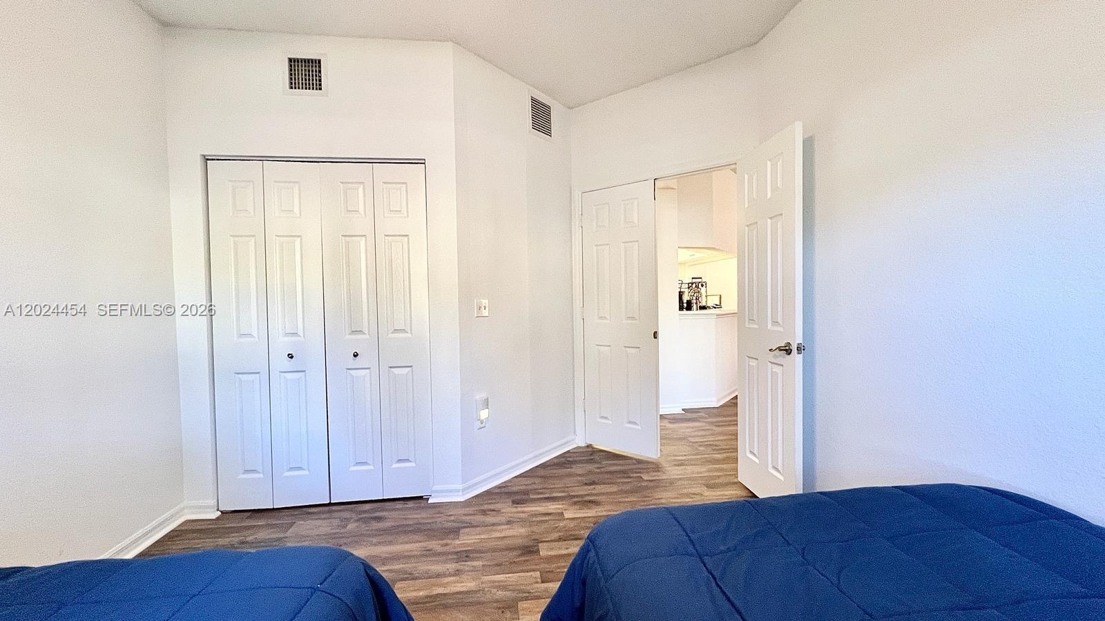 2727 Anzio Court, Unit 106 Palm Beach Gardens, FL 33410 - Photo 25 of 43 a bedroom with a bed and wooden floor