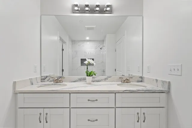 a bathroom with a sink double vanity and a mirror