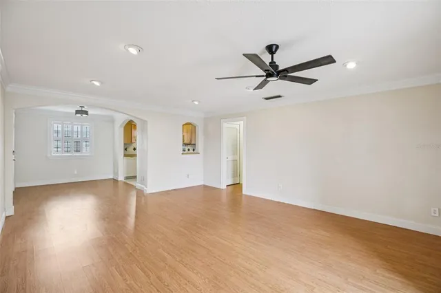 a view of an empty room with a window and wooden floor