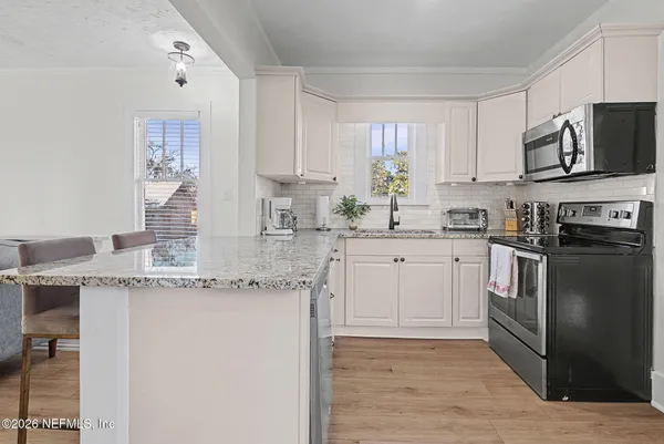 a kitchen with stainless steel appliances granite countertop a stove a sink and a refrigerator