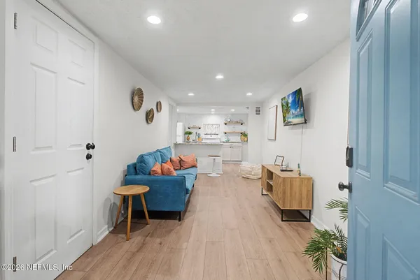 a living room with furniture and a wooden floor