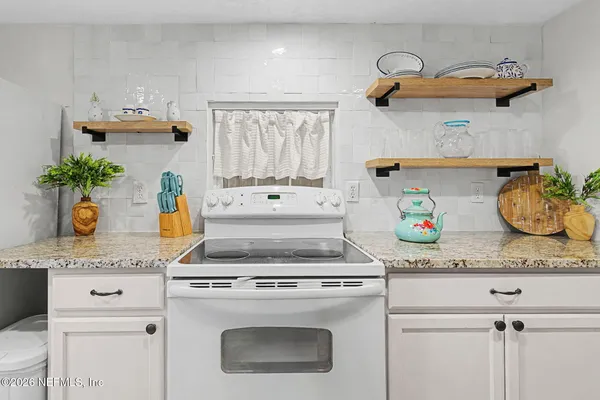 a kitchen with a stove a microwave and cabinets
