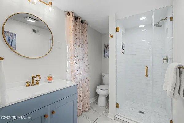 a bathroom with a sink a toilet and shower