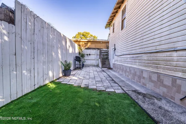 a view of a backyard with wooden fence