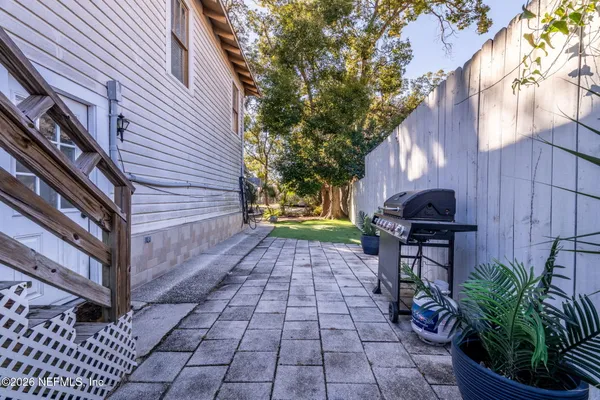 a view of a patio with table and chairs with wooden fence and plants