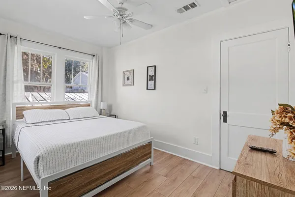 a bedroom with a bed and wooden floor
