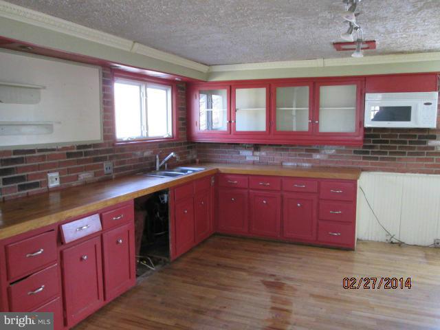 11003 Keymar Road Woodsboro, MD 21798 - Photo 12 of 15 a kitchen with stainless steel appliances granite countertop a sink stove and cabinets