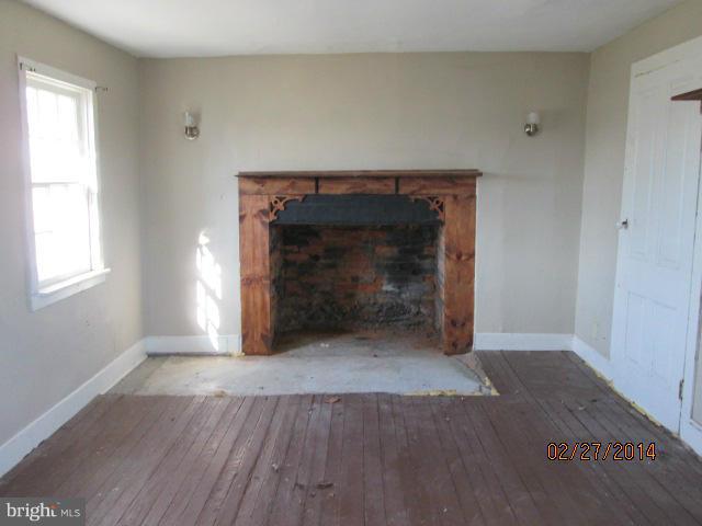 11003 Keymar Road Woodsboro, MD 21798 - Photo 15 of 15 an empty room with wooden floor fireplace and windows