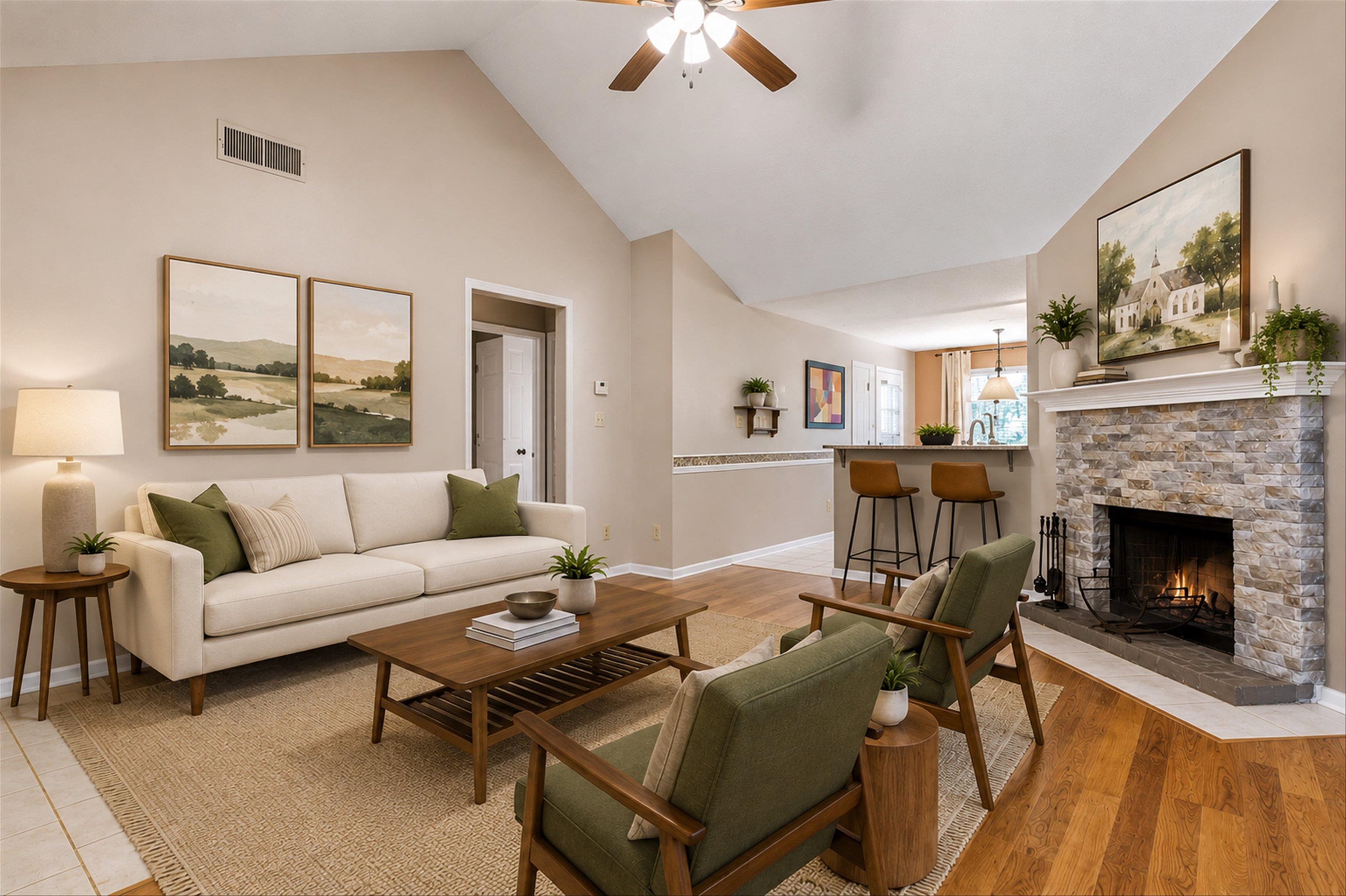 Vaulted ceiling living room featuring a stone-clad fireplace with a hearth, wood-finish flooring, and a ceiling fan