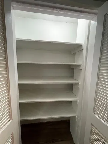 a view of walk in closet with empty racks