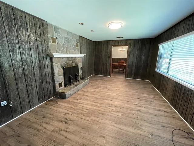 wooden floor fireplace and windows in an empty room