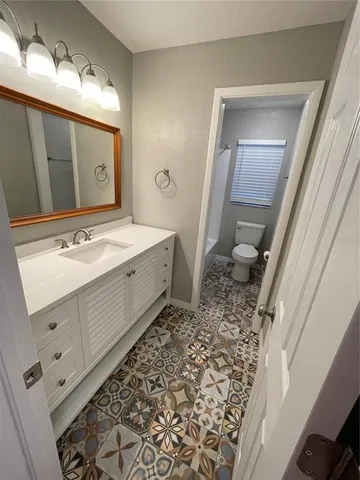 a bathroom with a sink a toilet and a mirror