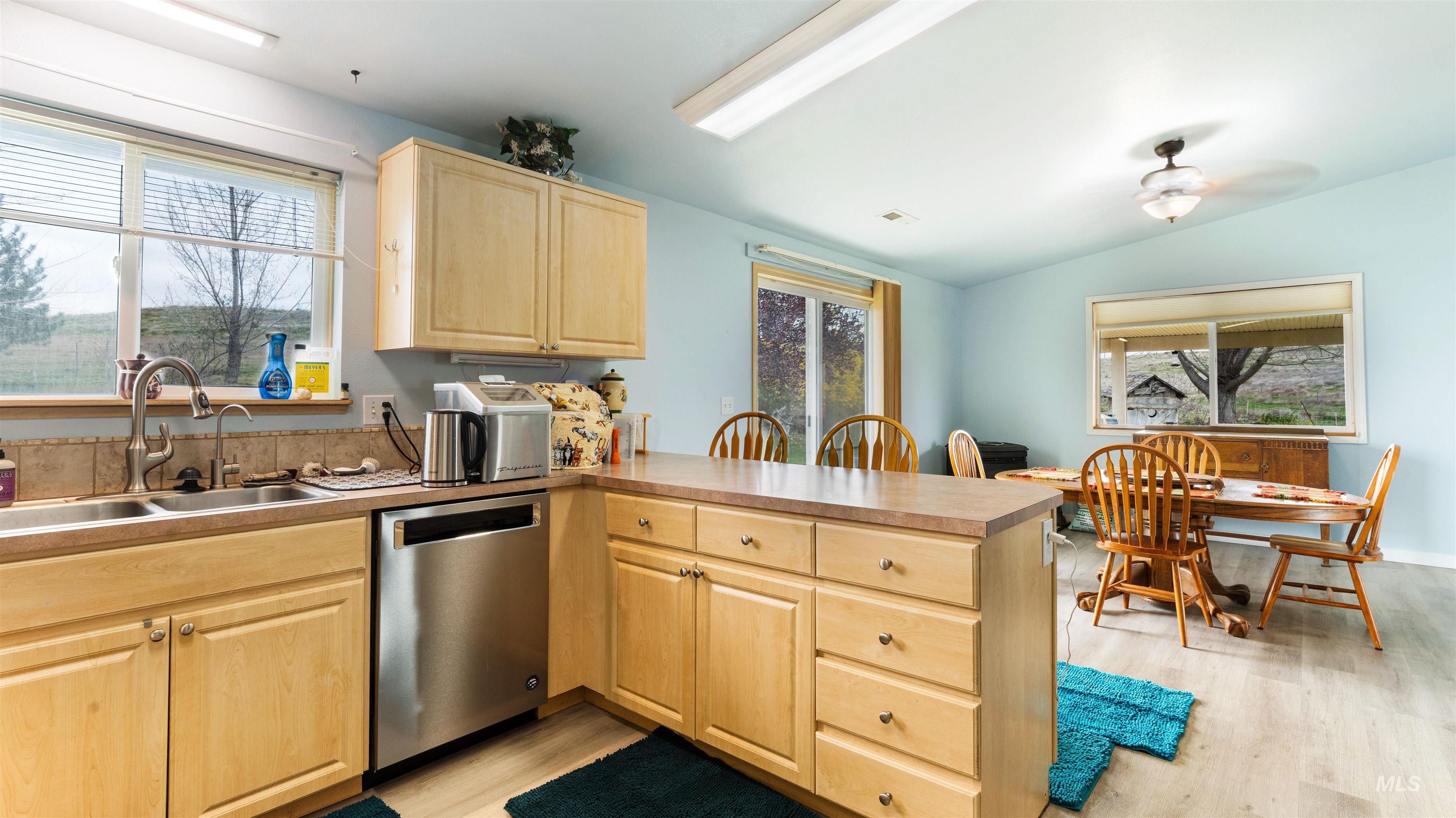 731 Tower Lane Caldwell, ID 83607 - Photo 27 of 38 Kitchen featuring a peninsula, light wood finish cabinets, dishwasher, light wood-style floors, and lofted ceiling