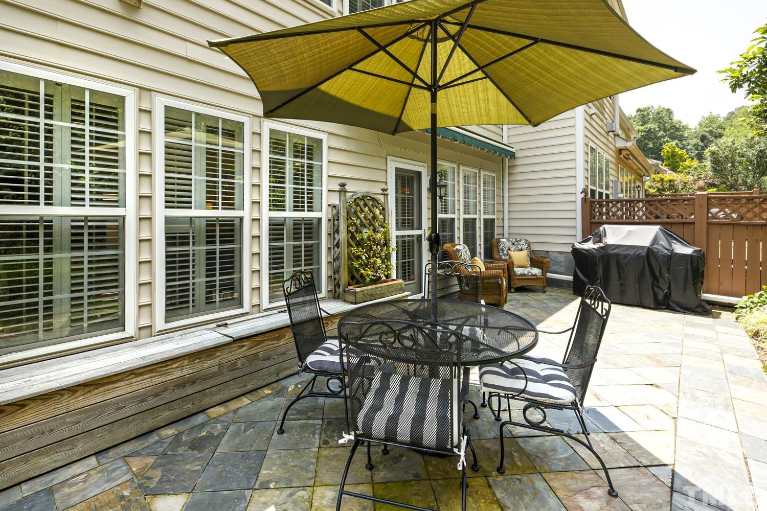 3917 Sunset Maple Court Raleigh, NC 27612 - Photo 11 of 54 a view of a patio with a table and chairs under an umbrella
