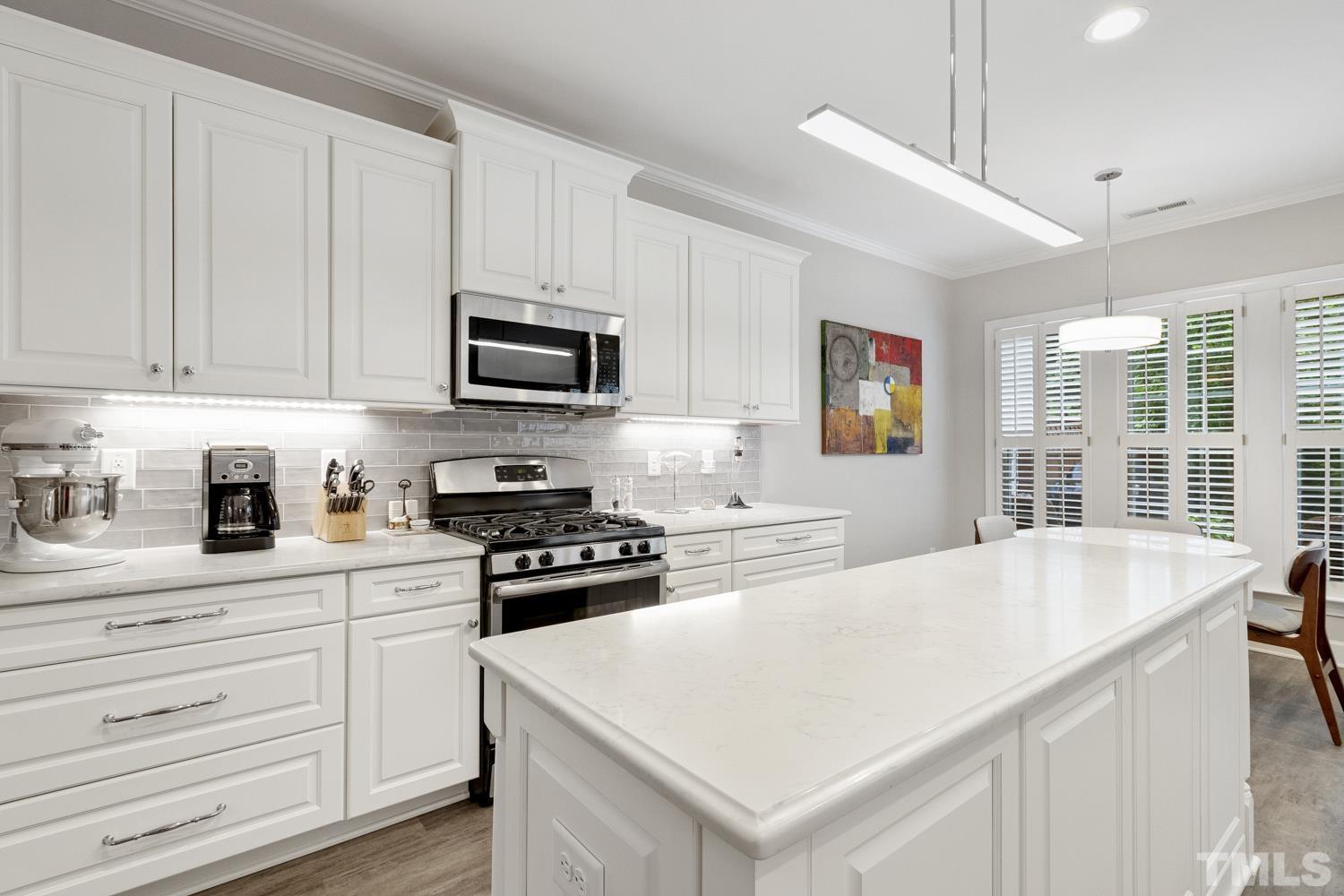 3917 Sunset Maple Court Raleigh, NC 27612 - Photo 8 of 54 a kitchen with granite countertop a stove a sink and a refrigerator