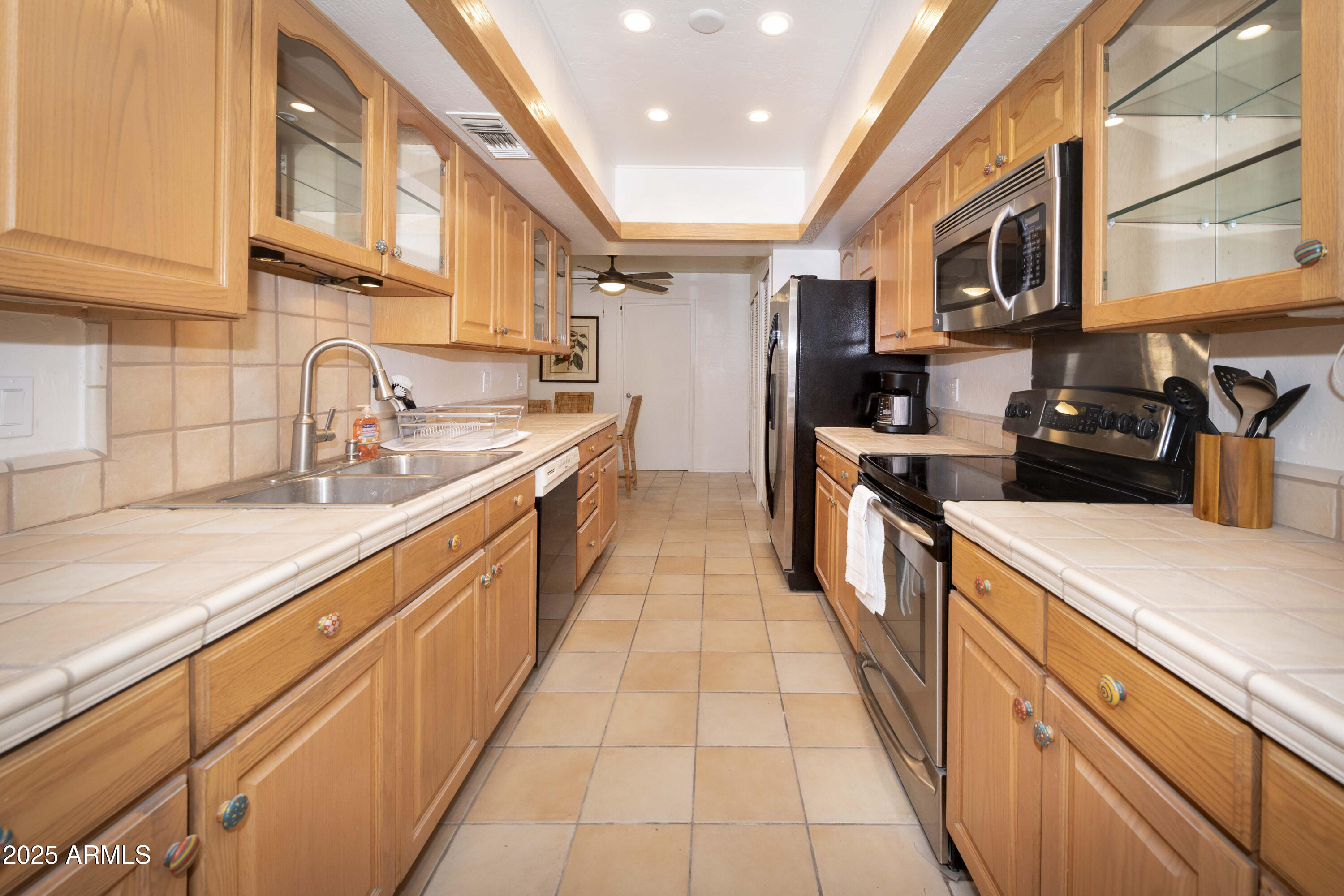4446 East Camelback Road, Unit 109 Phoenix, AZ 85018 - Photo 13 of 42 a large kitchen with stainless steel appliances granite countertop a large stove top oven a sink dishwasher and wooden cabinets