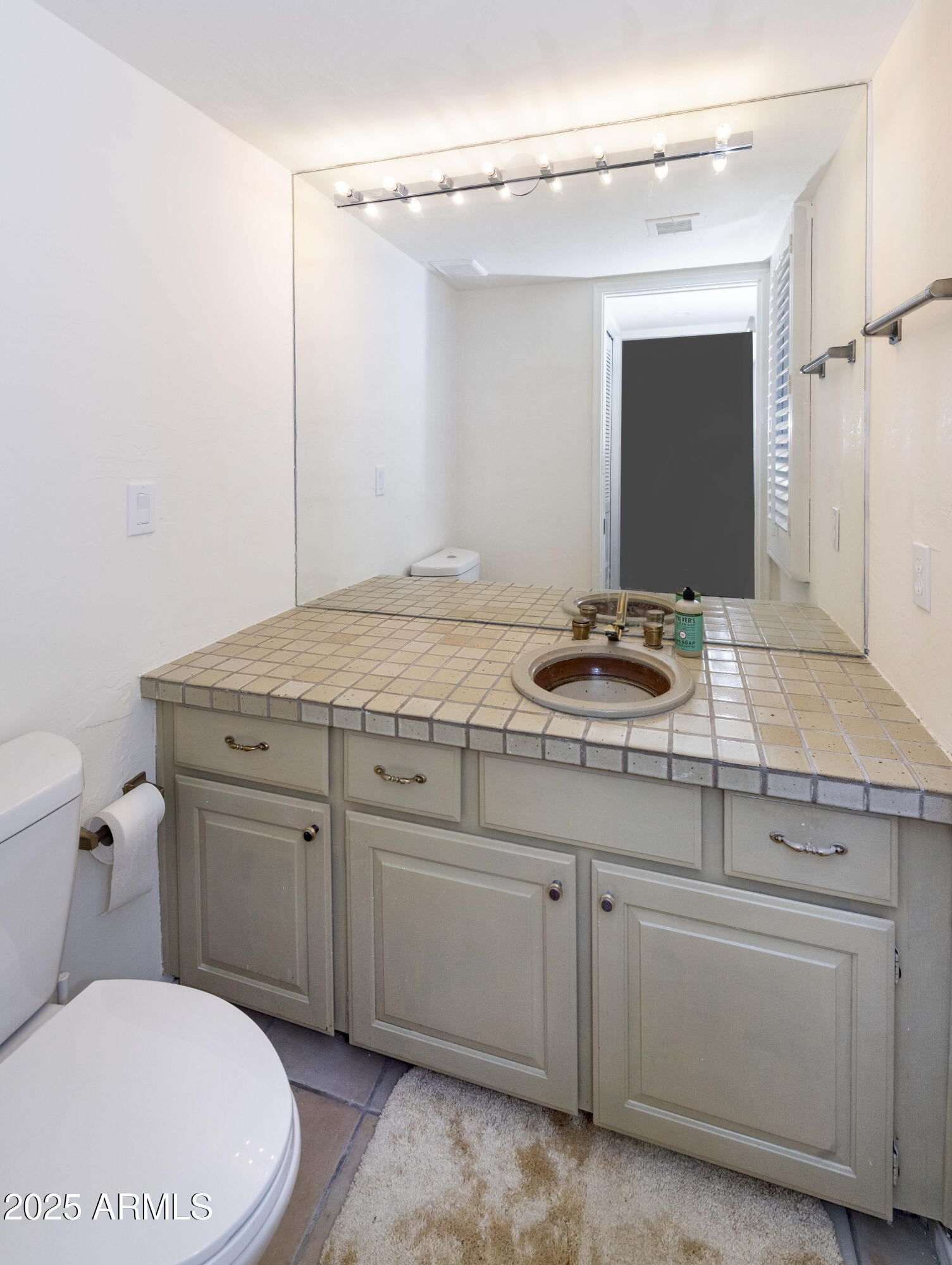 4446 East Camelback Road, Unit 109 Phoenix, AZ 85018 - Photo 18 of 42 a bathroom with a granite countertop toilet sink and mirror