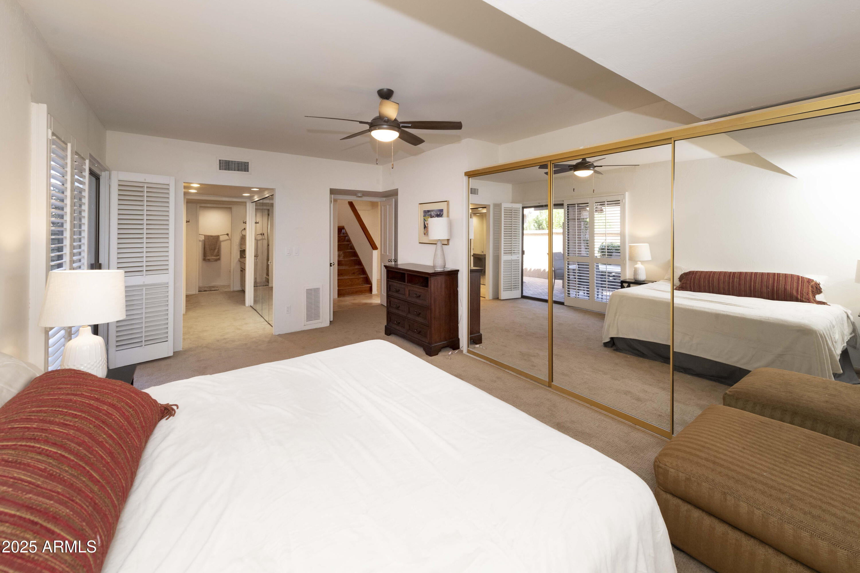 4446 East Camelback Road, Unit 109 Phoenix, AZ 85018 - Photo 20 of 42 a bedroom with a large bed a chandelier and flat screen tv