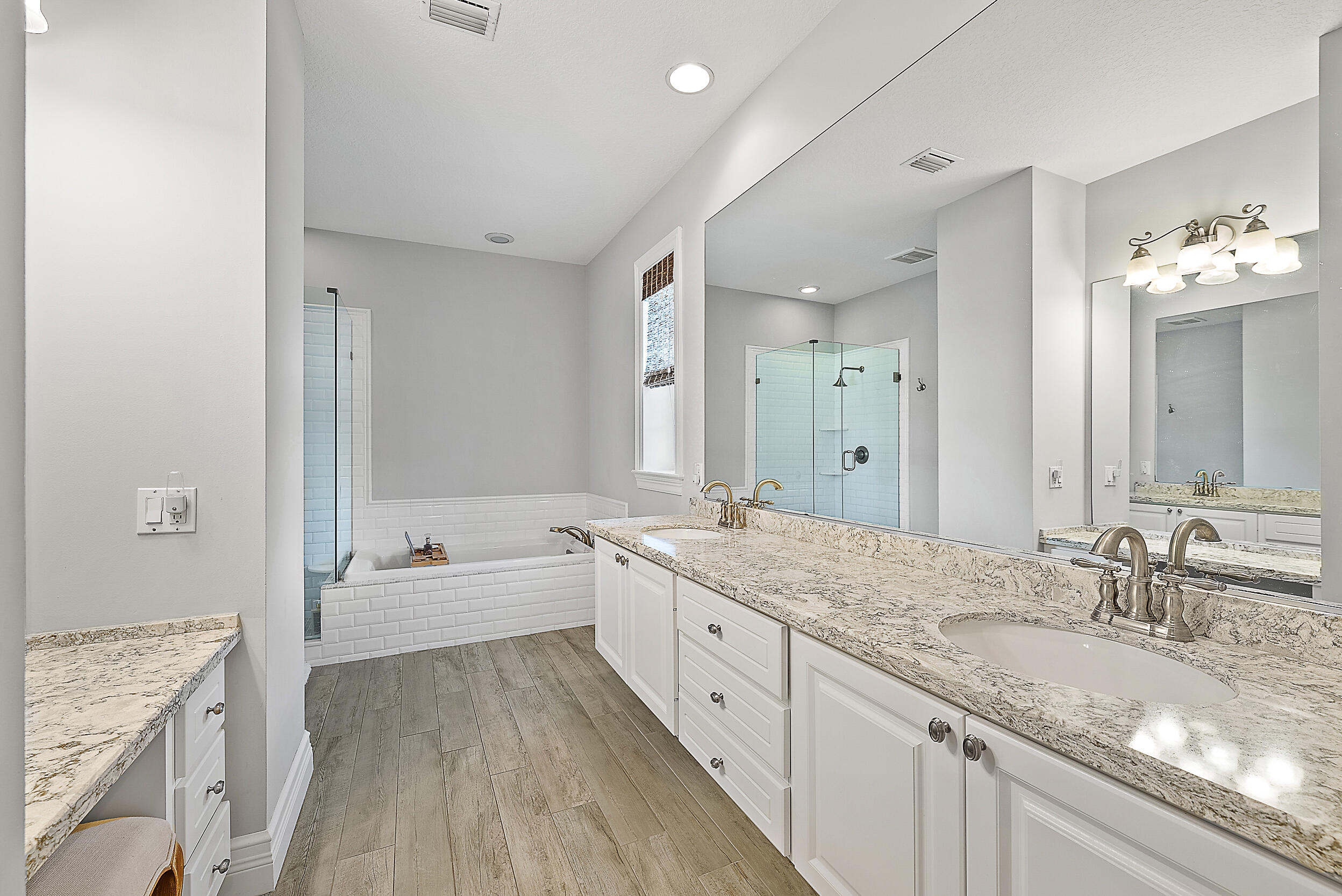 140 Sweet Bay Circle Jupiter, FL 33458 - Photo 21 of 36 a spacious bathroom with a granite countertop double vanity sink a mirror and a bathtub