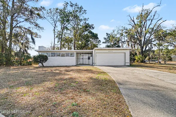 a view of a house with a yard and tree