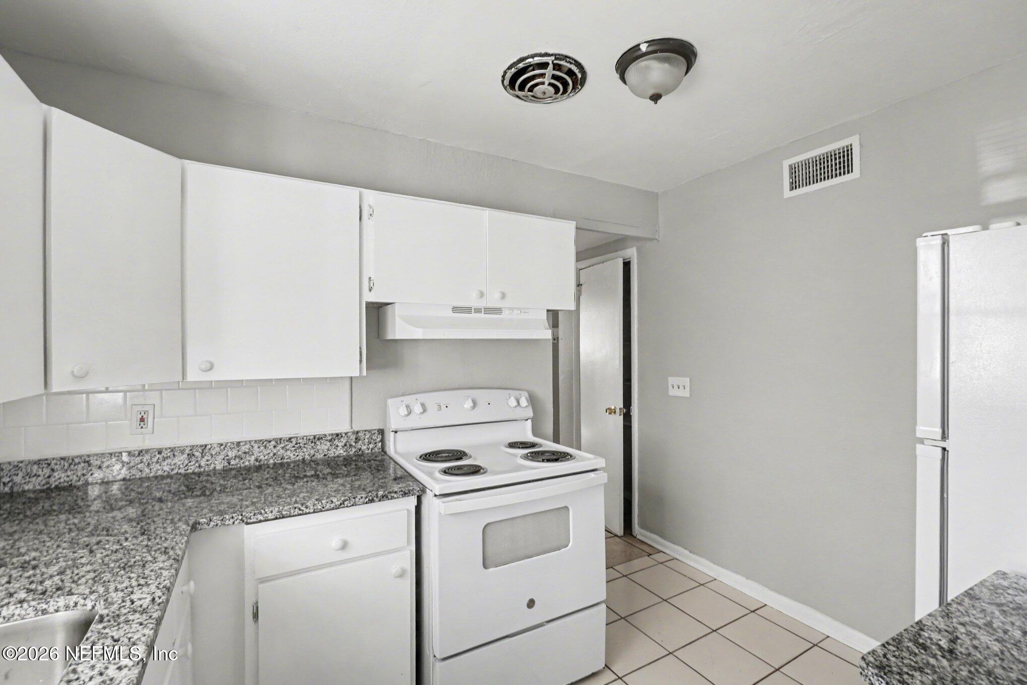 4852 Hatteras Road Jacksonville, FL 32208 - Photo 7 of 15 a kitchen with a stove and a refrigerator