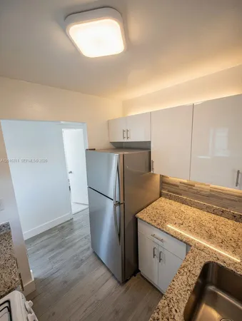 a kitchen with a refrigerator and a sink