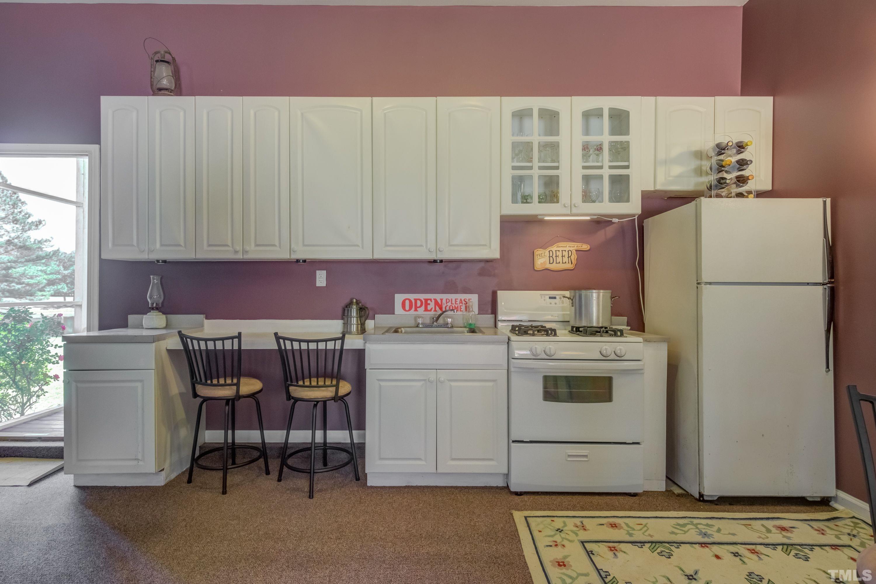 5646 Red Hill Church Road Coats, NC 27521 - Photo 21 of 31 a kitchen with a white stove top oven and white cabinets
