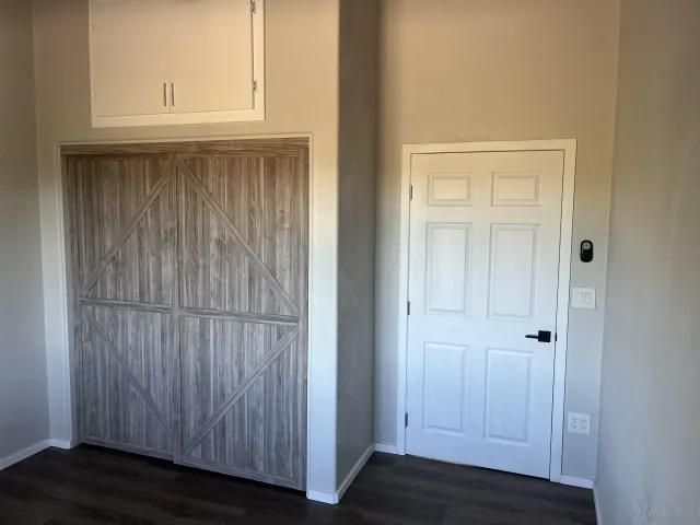 an empty room with wooden floor and cabinet