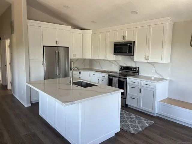 a kitchen with white cabinets stainless steel appliances and sink