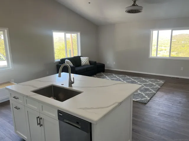 a kitchen with a sink and wooden floor