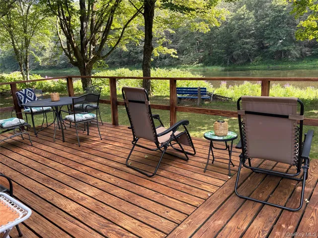 a view of a lake with wooden deck and outdoor seating