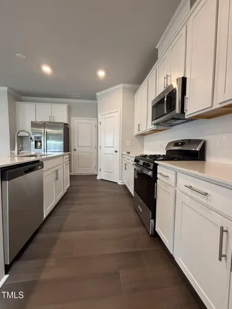 a view of a kitchen with a sink and a refrigerator