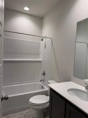 a bathroom with a granite countertop toilet sink and mirror