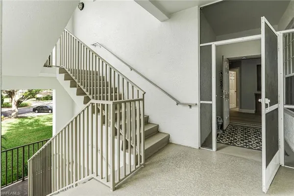 a view of staircase with railing and white walls