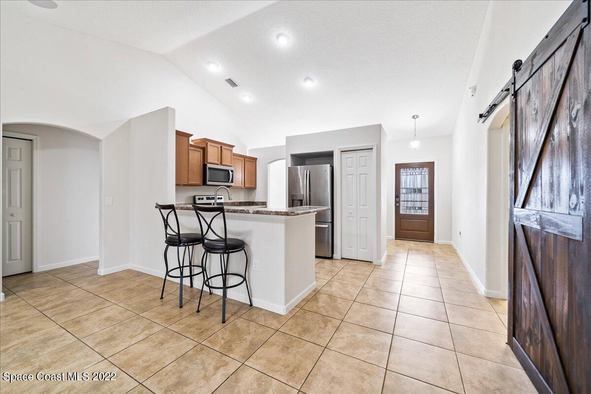 6175 Adina Road Cocoa, FL 32927 - Photo 8 of 29 a kitchen with stainless steel appliances a refrigerator and a stove top oven