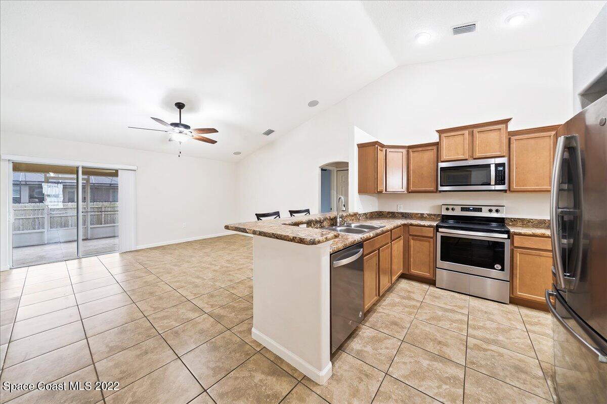 6175 Adina Road Cocoa, FL 32927 - Photo 9 of 29 a kitchen with stainless steel appliances granite countertop a stove and a sink