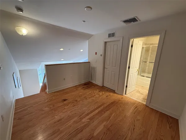 a view of empty room with wooden floor